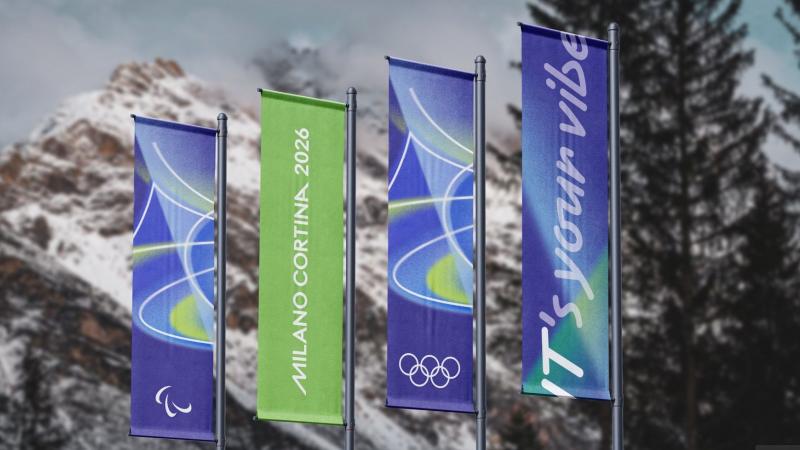 A photo of four blue and green flags in front of a mountain. 